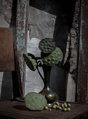 新鲜的绿色莲花种子豆荚古董雕刻铁壶花瓶木椅子