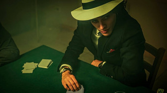 年轻的男人。戏剧扑克朋友绿色变形扑克表格喝玻璃