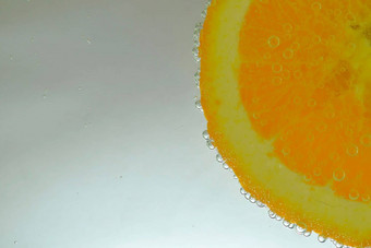 特写镜头橙色片液体泡沫片成熟的橙色水果水特写镜头新鲜的橙色片覆盖泡沫