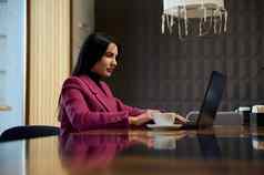 成功的女商人移动PC发展中行动计划业务项目坐着表格杯咖啡