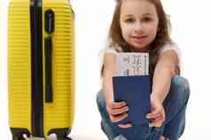 细节登机通过身份文档旅行在国外手女孩旅行者黄色的手提箱