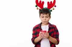 可爱的高加索人孩子男孩鹿鹿角希望头使圣诞节吹红色的蜡烛