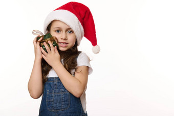 肖像白色可爱的女孩穿圣诞老人他轻轻拥抱圣诞节礼物相机