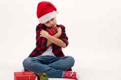 可爱的孩子男孩圣诞老人他轻轻拥抱圣诞节礼物孤立的白色背景复制广告空间