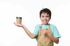 可爱的孩子男孩美丽的微笑穿酋长围裙指出手指纸板杯外卖咖啡
