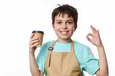 孤立的肖像白色背景快乐十几岁的男孩酒保显示标志销售外卖咖啡生态纸杯