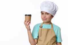 英俊的十几岁的男孩酋长他米色围裙销售外卖热饮料咖啡茶生态纸杯