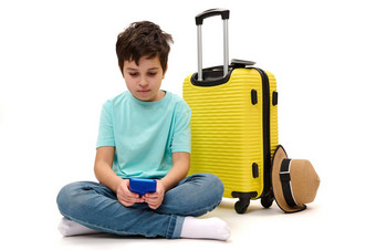 少年男孩蓝色的t恤黄色的手提箱滚动新闻饲料检查社会媒体内容智能手机