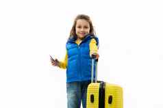 高加索人可爱的孩子女孩蓝色的夹克黄色的套衫摆姿势旅行袋登机通过白色