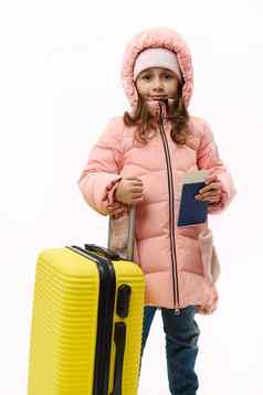 全身的肖像女孩粉红色的外套摆姿势手提箱登机通过白色背景