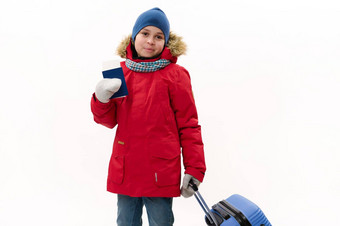 快乐旅行者男孩红色的派克大衣牛仔裤羊毛连指手套冬天假期走空气票蓝色的手提箱