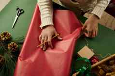 特写镜头女人的手计算量包装纸包装圣诞节礼物绿色背景拳击一天