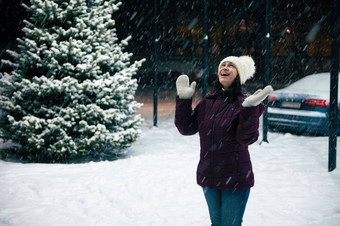 快乐的女人温暖的衣服喜乐雪站雪街照亮一年的花环