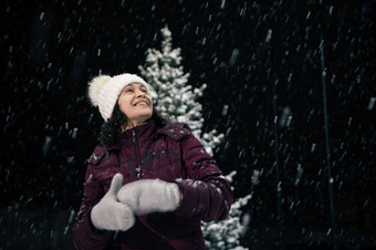 令人愉快的女人温暖的衣服享受圣诞节大气在户外雪晚上降雪快乐圣诞节