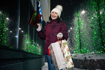迷人的年轻的女人走街购物袋圣诞节礼物盒子手快乐圣诞节