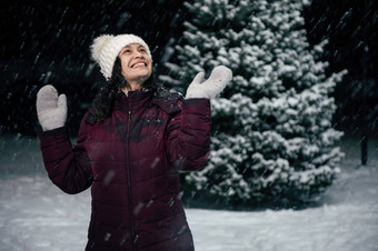 令人愉快的快乐女人有趣的捕捉雪花站雪覆盖自然雪冷冬天晚上