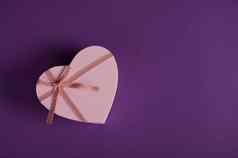 前视图圣情人节一天装饰心形状的礼物盒子粉红色的丝带弓孤立的紫色的背景