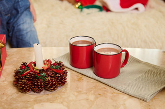 红色的杯热可可喝绿色餐巾装饰圣诞节基斯蜡烛大理石表格
