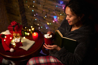 令人愉快的女人杯热巧克力享受阅读烛光神奇的冬天大气
