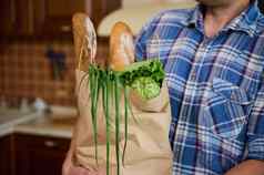 裁剪视图生态纸购物袋饼粮食面包健康的素食主义者食物男人的手