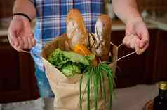 特写镜头生态购物袋食品杂货手认不出来男人。拆包有益健康的健康的食物