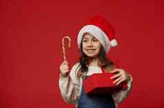 快乐可爱的孩子女孩圣诞老人他持有糖果狗圣诞节现在红色的背景复制空间