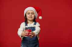 可爱的可爱的女孩圣诞老人他微笑相机持有基斯蜡烛孤立的红色的背景