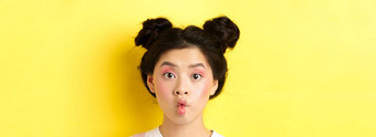 特写镜头青少年朝鲜文女孩皱<strong>纹嘴唇</strong>有趣的相机站魅力化妆时尚的发型黄色的背景
