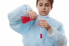 细节手学校男孩科学家化学家倒红色的化学物质平触底瓶测试管