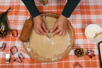前视图女老板糖果店手切割心形状的模具姜饼面团使自制的糕点