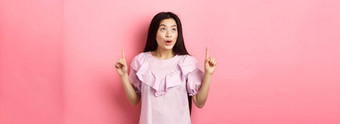 兴奋青少年亚洲女人指出手指梦幻空空间站衣服粉红色的背景