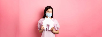 真正的房地产流感大流行概念年轻的亚洲女人医疗面具做梦首页显示纸房子断路站粉红色的背景