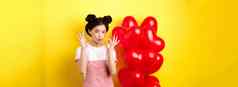 可爱的年轻的亚洲女人时尚的衣服化妆显示迹象情人节一天心气球赞美好提供站黄色的背景