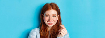 头像可爱的高加索人女人红色的头发雀斑显示心标志微笑站蓝色的背景