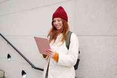 年轻的红色头发的人女人红色的他数字平板电脑在户外站街小工具连接无线网络互联网搜索位置互联网
