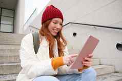 快乐时尚的红色头发的人女孩学生红色的他持有数字平板电脑社会媒体应用程序搜索在线连接无线网络