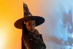 漂亮的年轻的女巫万圣节庆祝活动肖像可爱的十几岁的女孩摆姿势工作室女巫的服装魔法魔杖手混合色彩斑斓的照明