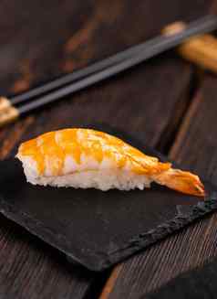 日本海鲜寿司尼吉里虾黑色的木背景亚洲厨房概念