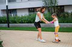 妈妈。帮助女儿学习辊滑冰