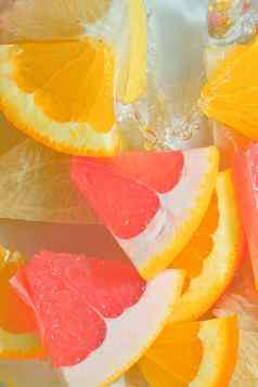 新鲜的片葡萄柚橙色水果蜂蜜葡萄柚白色背景块葡萄柚橙色水果蜂蜜葡萄柚闪闪发光的水白色背景特写镜头垂直宏图像前视图平设计夏天水果背景