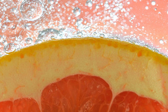 特写镜头葡萄柚片液体泡沫片红色的成熟的葡萄柚水特写镜头新鲜的葡萄柚片红色的白色背景