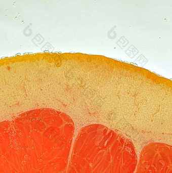 特写镜头葡萄柚片液体泡沫片红色的成熟的葡萄柚水特写镜头新鲜的葡萄柚片红色的白色背景