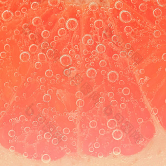 特写镜头葡萄柚片液体泡沫片红色的成熟的葡萄柚水特写镜头新鲜的葡萄柚片覆盖泡沫