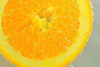特写镜头橙色片液体泡沫片橙色水果水特写镜头新鲜的橙色片覆盖泡沫