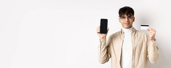 在线购物年轻的现代的家伙显示塑料信贷卡空智能手机屏幕演示账户站白色背景