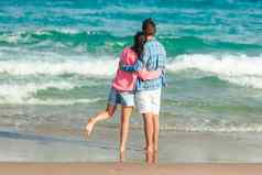 年轻的夫妇爱海滩夏天假期快乐男人。女人享受时间