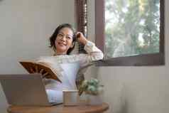 放松平静退休亚洲女人窗口做白日梦阅读书首页生活房间生活方式概念