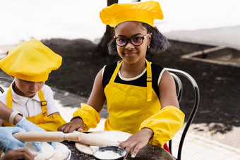 <strong>跨国公司</strong>公司孩子们厨师黄色的制服烹饪面团面包店非洲少年黑色的女孩有趣的高加索人孩子男孩烹饪食物