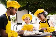 快乐公司多民族孩子们烹饪面团童年烹饪活动跨国公司孩子们黑色的非洲高加索人孩子们