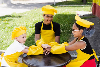 多民族的孩子们烹饪触碰手形成桩友谊<strong>跨国公司</strong>孩子们童年厨师厨师他黄色的围裙统一的把手